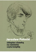 Chłopiec z kawką na ramieniu czyta książkę